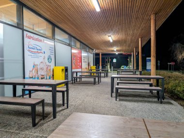 Fransa, Lyon 04 Şubat 2025: Masalar, banklar, reklamlar, aydınlatma tabelaları ile gece dinlenme alanı