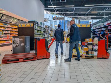 Fransa, 11 Nisan 2025: Hayvan maması reyonunda raf düzenleyen süpermarket çalışanları