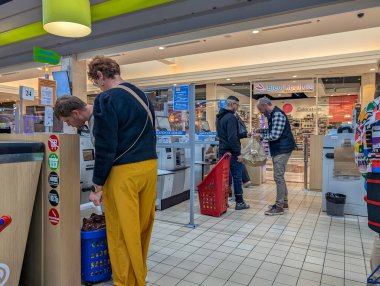 Fransa, 28 Mart 2025: Alışverişçiler bugün yoğun perakende sektöründe kendi kendine çıkış yapan büfeleri kullanıyorlar