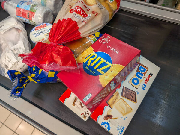 France, 26 March 2025 : Grocery items on conveyor belt in supermarket checkout line scene.