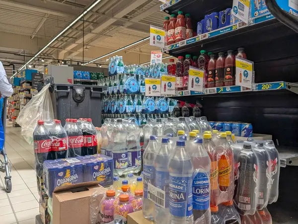 Fransa, 03 Mayıs 2025: Meşgul süpermarket koridorlarında çeşitli meşrubat ve su şişeleri sergilendi