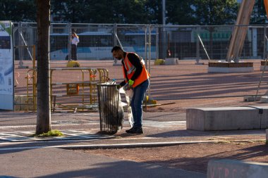 Fransa, 13 Mayıs 2025: Belediye işçisi şehir parkı inşaat alanında çöp topluyor