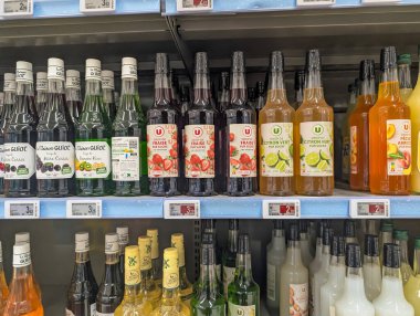 Fransa, 03 Mayıs 2025: Süpermarket raflarında çeşitli meyve aromalı şurup şişeleri