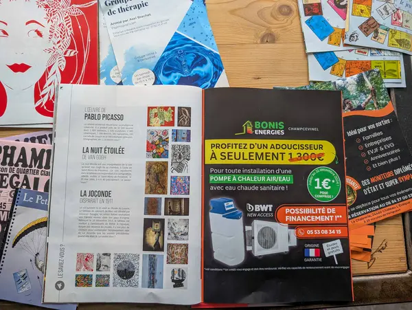 Fransa, 09 Mart 2025: Ahşap masaya saçılmış renkli dergiler ve broşürler