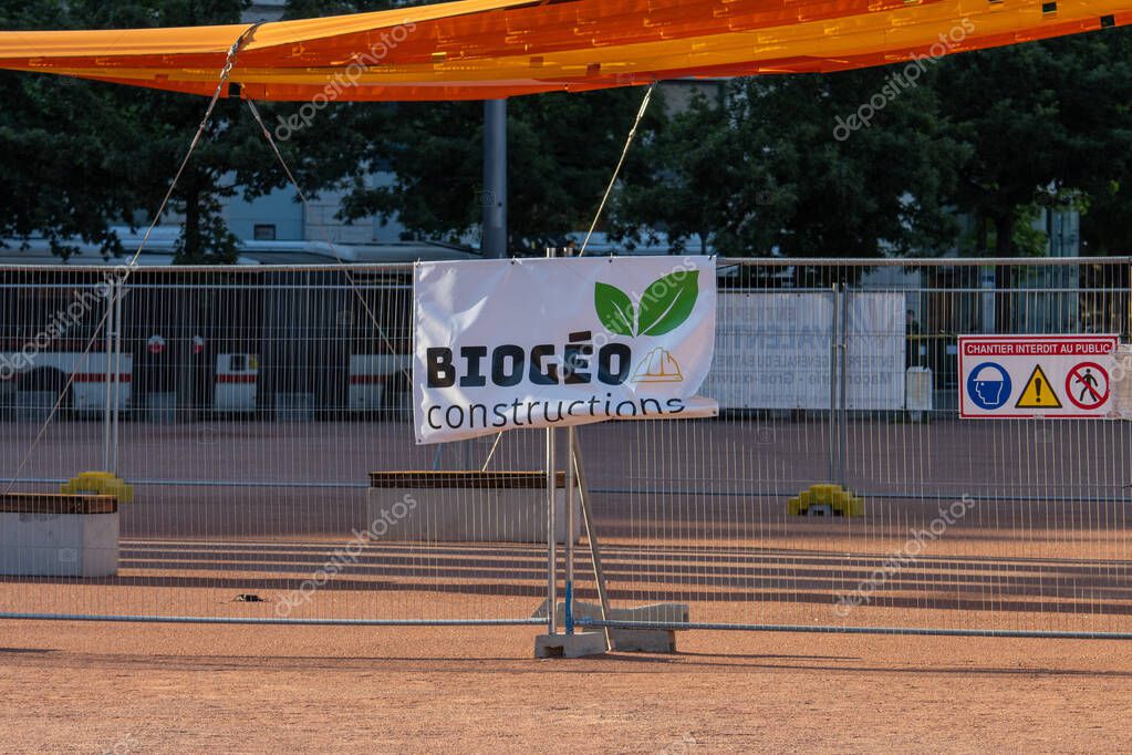 France, 13 May 2025 : Construction site banner with safety warning signs and green leaves.