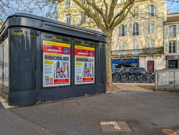 Fransa, 04 Nisan 2025: Kentsel cadde yakınlarındaki emlak reklamlarını gösteren gazete bayii.