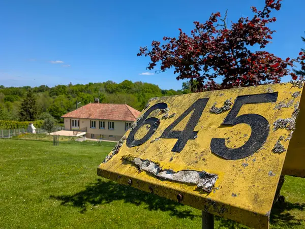 Fransa, 25 Nisan 2025: Kırsal kesim yakınlarındaki koyu siyah sayılı sarı tabela