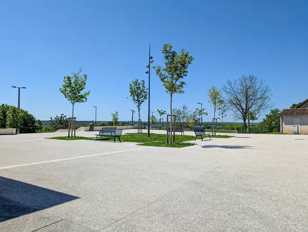 Fransa, 25 Nisan 2025: Banklar, yeşil ağaçlar, açık mavi gökyüzü