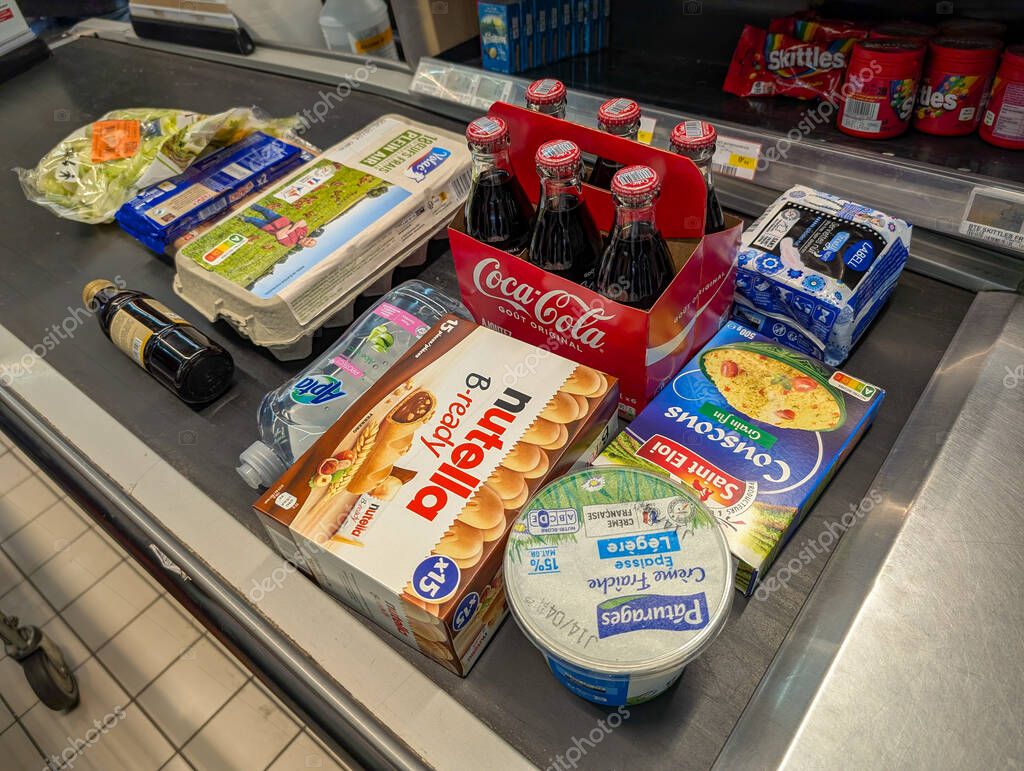 France, 24 March 2025 : Grocery shopping items on checkout conveyor in supermarket scene