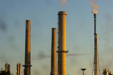 Fransa, 13 Mayıs 2025: Uzun sanayi bacaları açık mavi sabah gökyüzüne duman salıyor