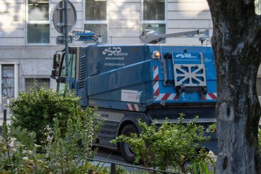 Fransa, 13 Mayıs 2025: Mavi sokak temizleme aracı şehir caddesinde çalılıkların yanına park edildi