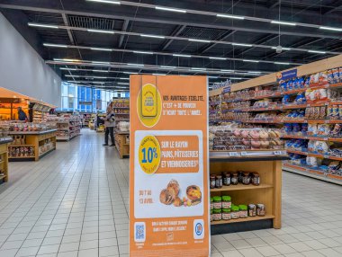 Fransa, 11 Nisan 2025: Reklam işareti ve renkli ürünler sergilenen market koridoru