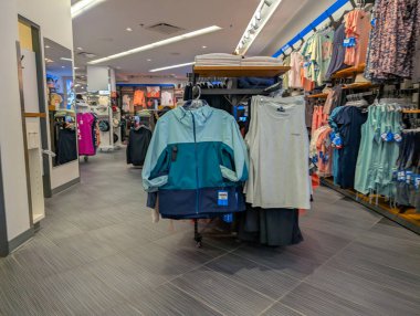 Quebec, Kanada, 05 Temmuz 2025: Renkli gömlekler, ceketler ve aksesuarlar arasında alışveriş