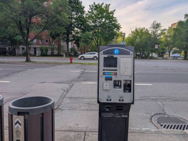 Quebec, Kanada, 05 Temmuz 2025: Şehir sokak parkmetresi çöp tenekeleri ve boş yol kenarında duruyor