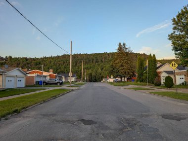 Quebec, Kanada, 09 Temmuz 2025: Sessiz mahalle sokakları evler, ağaçlar ve uzak ormanlarla dolu