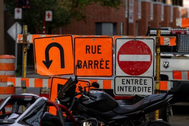 Quebec, Kanada, 05 Temmuz 2025: Kapalı inşaat tabelalarının önüne park edilmiş motosiklet, şehir manzarası