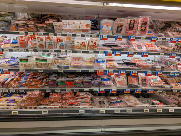 Quebec, Canada, 08 July 2025 : Refrigerated supermarket shelves filled with packaged meats and sale labels everywhere