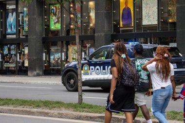 Quebec, Kanada, 05 Temmuz 2025: İnsanlar birlikte yürürken polis aracı sanat galerisinden geçiyor