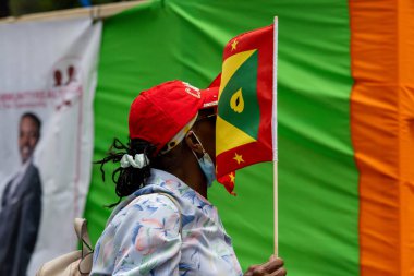 Quebec, Kanada, 05 Temmuz 2025: Kırmızı Şapkalı Kadın Grenada Bayrağı Giyiyor