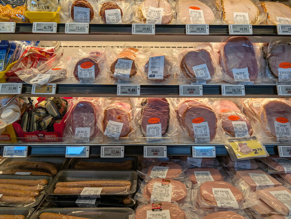 Canada, 08 July 2025 : Deli meats and sausages displayed in a brightly lit supermarket cooler