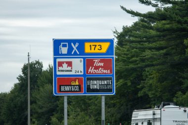 Quebec, Kanada, 20 Temmuz 2025: Çevredeki otoyol hizmetleri benzin, gıda ve restoran seçeneklerini gösteren tabela