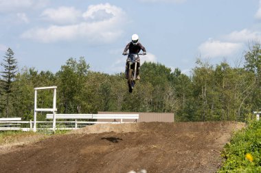 Quebec, Kanada, 20 Temmuz 2025: Motosiklet sürücüsü kırsal alanların üzerinde yükseliyor