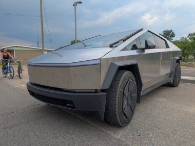 Kanada, 28 Temmuz 2025: Futuristik elektrik kamyonu yoldan geçen bisikletçinin yakınına park edildi