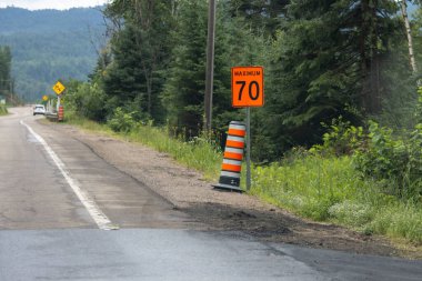 Kanada, 20 Temmuz 2025: Yoğun yeşil ormanın ortasında kırsal yol inşaat alanı maksimum hız tabelası