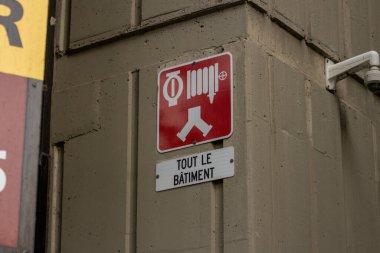 Quebec, Kanada, 05 Temmuz 2025: Fransız binasındaki beton duvara yangın hortumu acil durum işareti