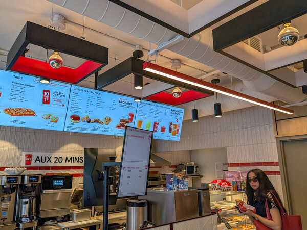 Канада, 20 июля 2025: Тим Хортонс счетчик отображает меню, клиент ждет ее заказ