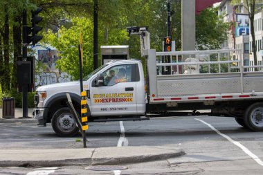 Quebec, Kanada, 05 Temmuz 2025: Şehir trafik işçisi kamyonu yeşil ağaçların yanındaki kavşakta bekliyor