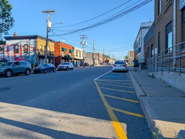 Quebec, Kanada, 08 Temmuz 2025: Akşam erken saatlerde park halindeki arabalarla sakin kentsel caddeyi aydınlattı