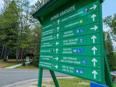 Quebec, Kanada, 15 Temmuz 2025: Yeşil yön işareti doğa merkezleri, şelale, piknik alanı, bilgi