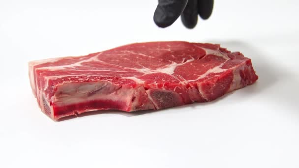 一只手拿起牛肉牛排 用白色背景隔开 慢动作 — 图库视频影像
