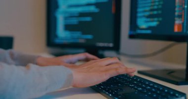 Kapalı genç yetişkin Asya kadın serbest yazma komut AI bot uygulama programı göçebe, video oyunu, kodlama dili, tasarımcı, gece ofisindeki masaüstü bilgisayarında büyük veri merkezi.