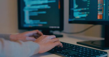 Kapalı genç yetişkin Asya kadın serbest yazma komut AI bot uygulama programı göçebe, video oyunu, kodlama dili, tasarımcı, gece ofisindeki masaüstü bilgisayarında büyük veri merkezi.