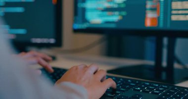 Kapalı genç yetişkin Asya kadın serbest yazma komut AI bot uygulama programı göçebe, video oyunu, kodlama dili, tasarımcı, gece ofisindeki masaüstü bilgisayarında büyük veri merkezi.