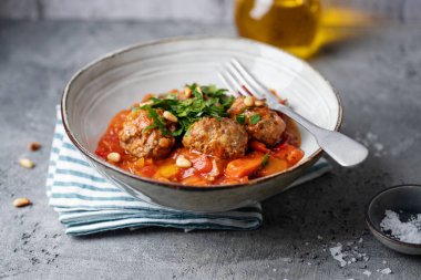 Meatballs with vegetables and tomato sauce served in bowl. Closeup 