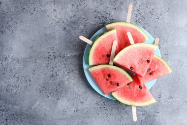 Watermelon cuts pieces on blue plate on bright background. Top View. Summer concept. 