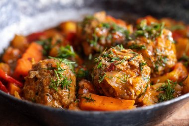 Meatballs with vegetables on pan on table. Closeup 