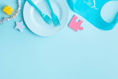 Blue plate with blue cutlery on blue background. Baby food concept. 