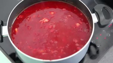 Çorba ya da güveç için evde sebze kızartan bir kadın. Sıcak, gerçek, ev yapımı yemek.