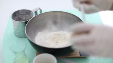 Kadın evde hamur tatlısı için maya ekliyor.