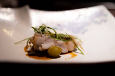 Restoranda yeşil salatalı bir balığın yüksek açı çekimi.