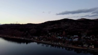 Göl manzaralı bir şehrin penceresinden. Akşam batımı.