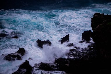 dalgalar üzerinde kayalık sahil breaking.