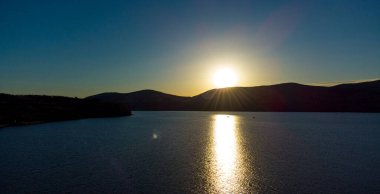 Akşamları dağlarla gölde gün batımı