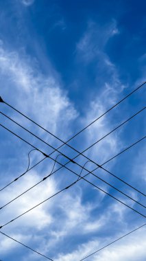 Mavi gökyüzünde yüksek voltajlı elektrik hatları