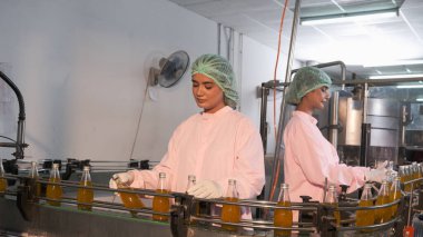 Güney Asyalı kadın fabrika işçisi veya kadın uzman personel içki kuyruğuna bakıyor