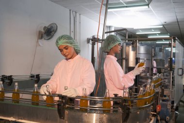 Güney Asyalı kadın fabrika işçisi veya kadın uzman personel içki kuyruğuna bakıyor